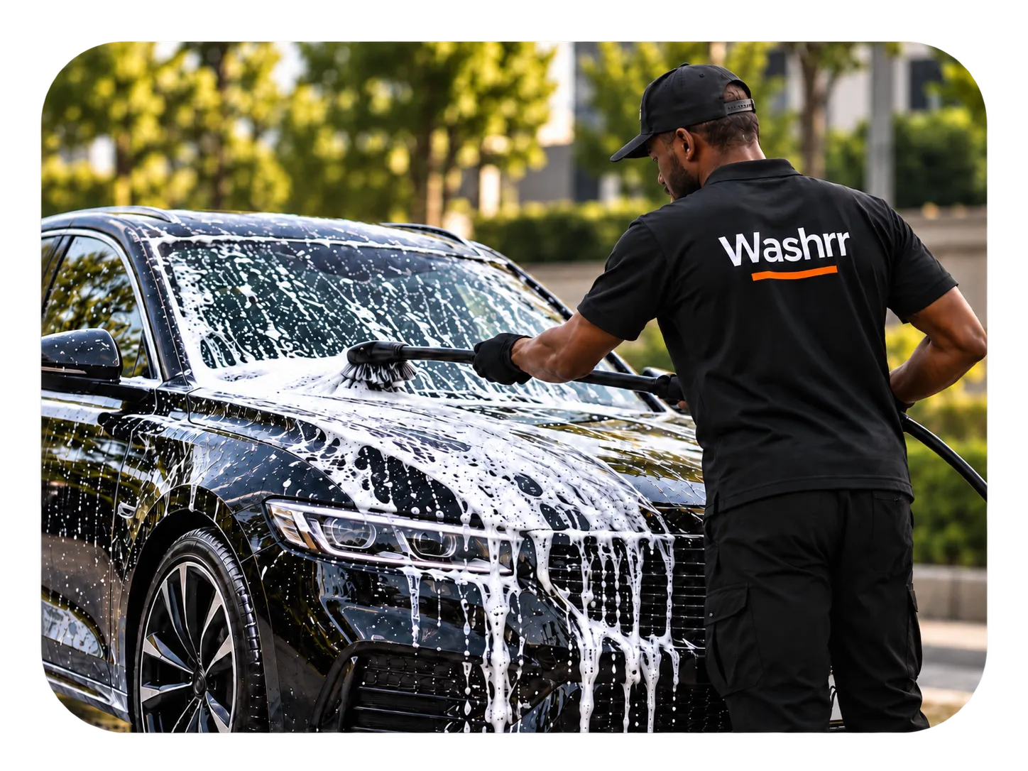 A Washrr washer hand-washing a car with soap and a brush